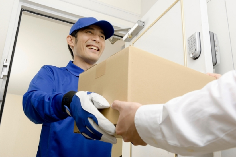 荷物を手渡しするスタッフの写真